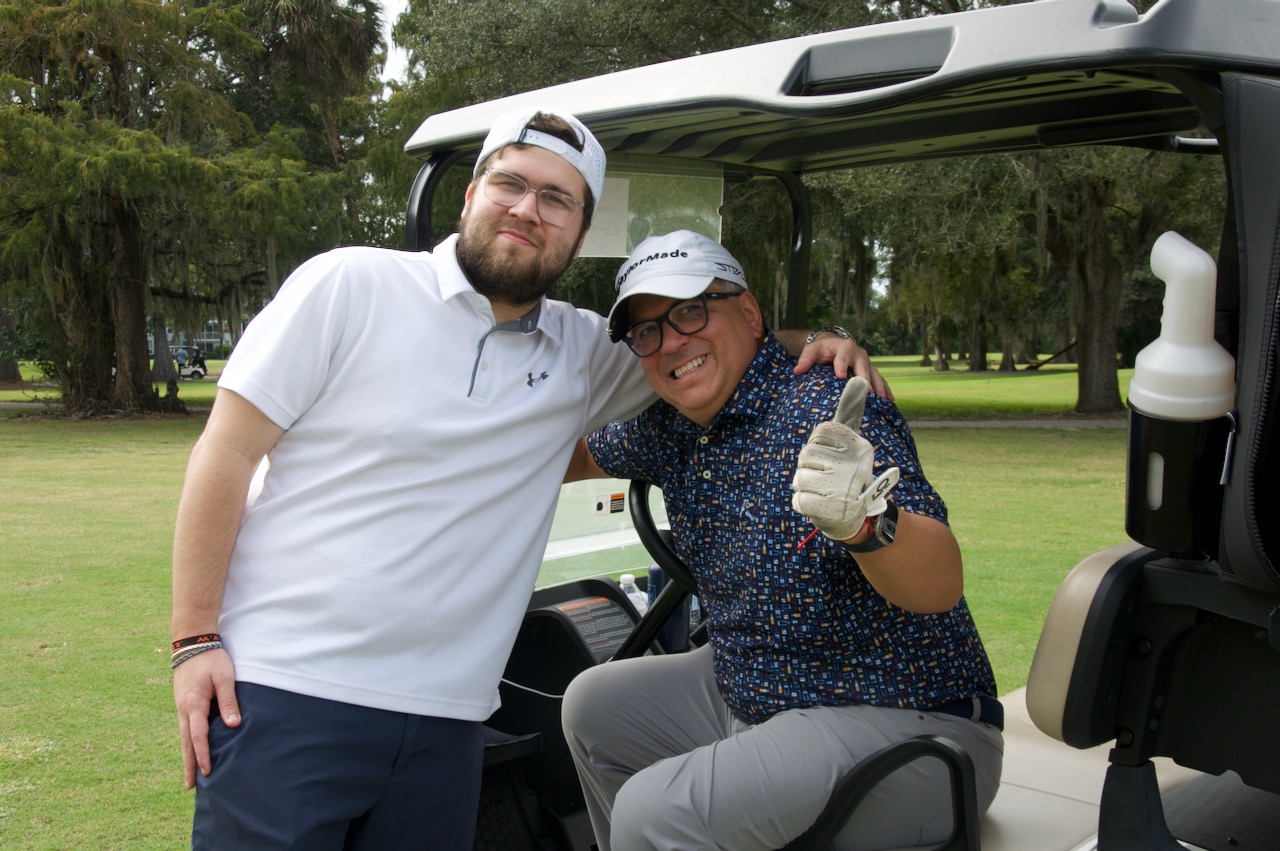 Two players in a cart giving a thumbs up
