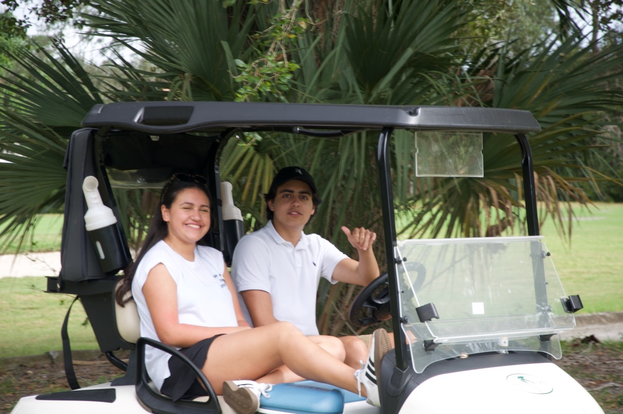 Two young players seated in their cart