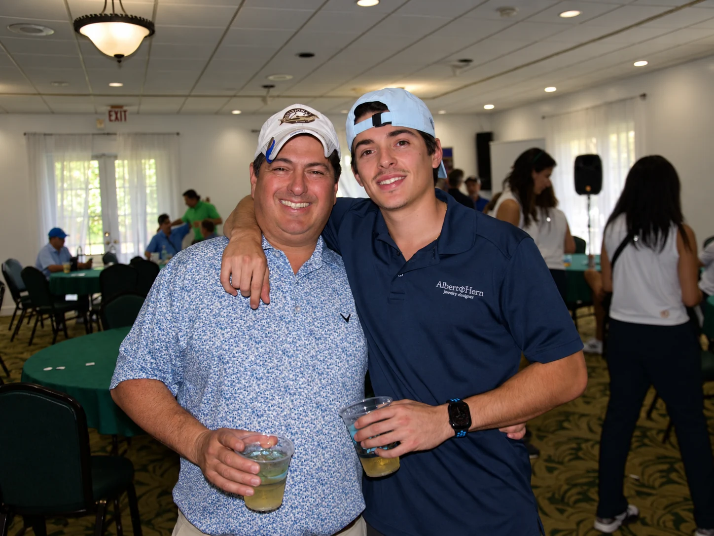Two players with drinks at the post-round reception