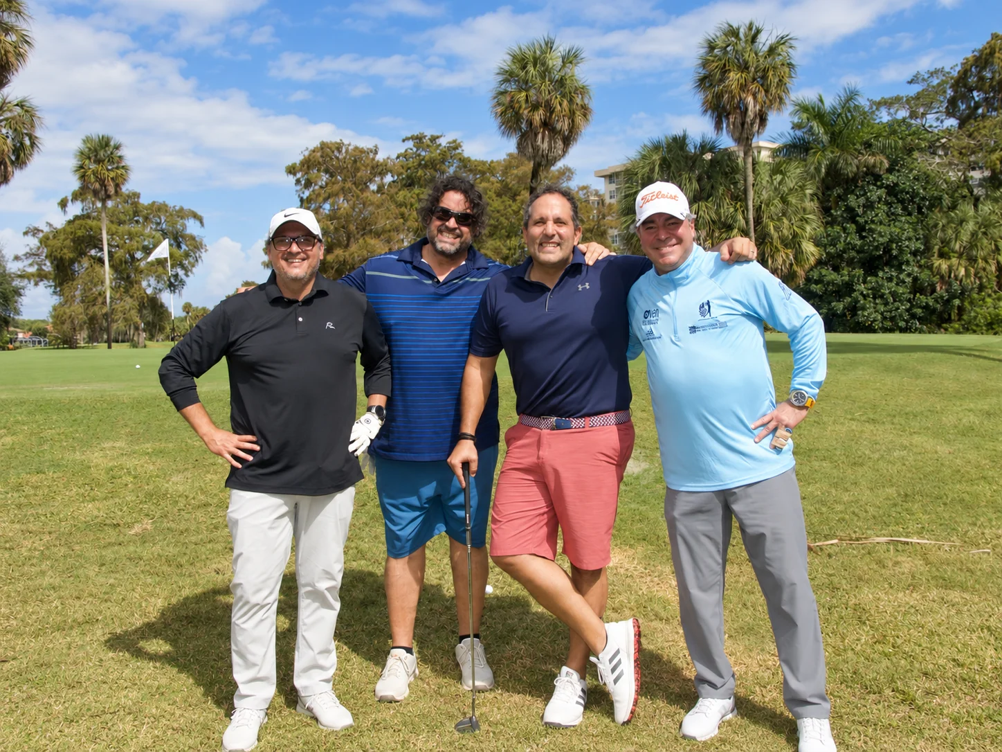 A foursome posing on the fairway at Palm Aire