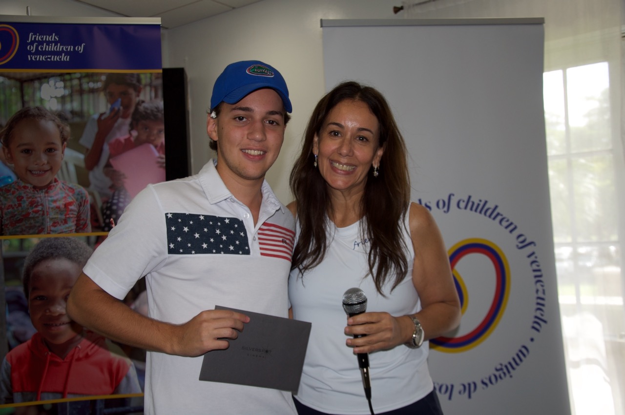 Prize presentation in front of the Friends of Children of Venezuela banners