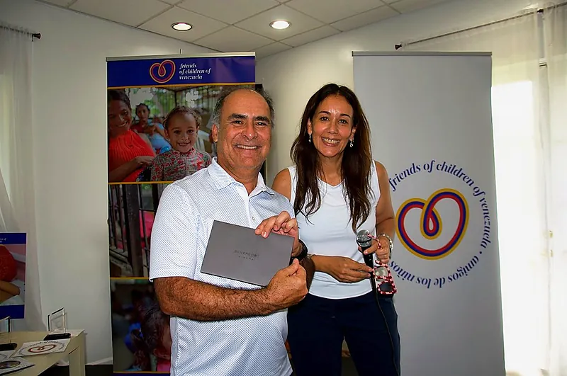 Award presentation in front of the Friends of Children of Venezuela banners