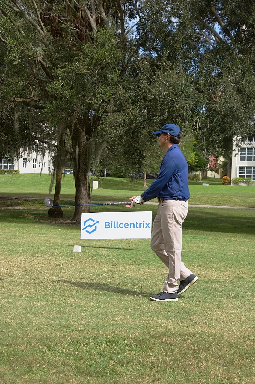 A player teeing off beside the Billcentrix sponsor sign