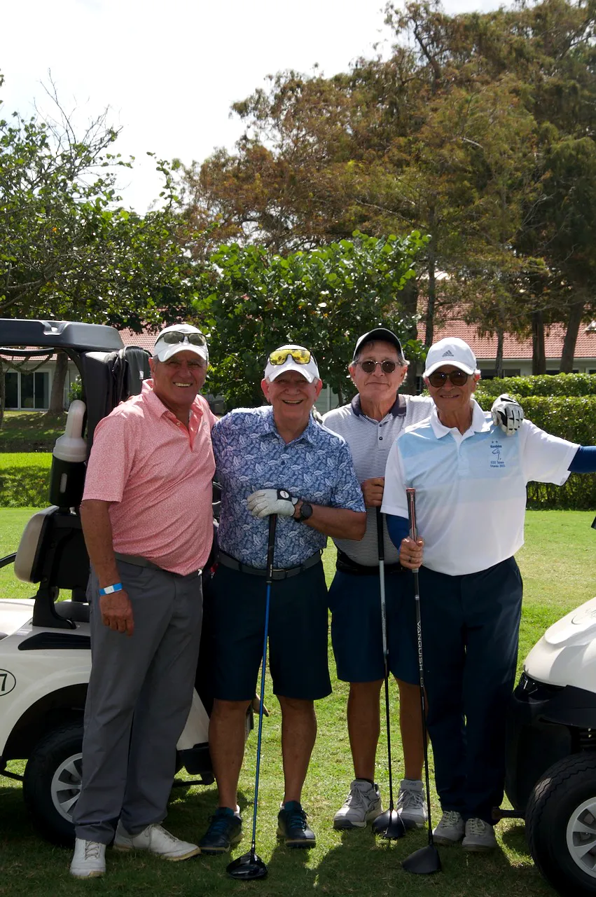 A foursome posing with their drivers beside cart 7