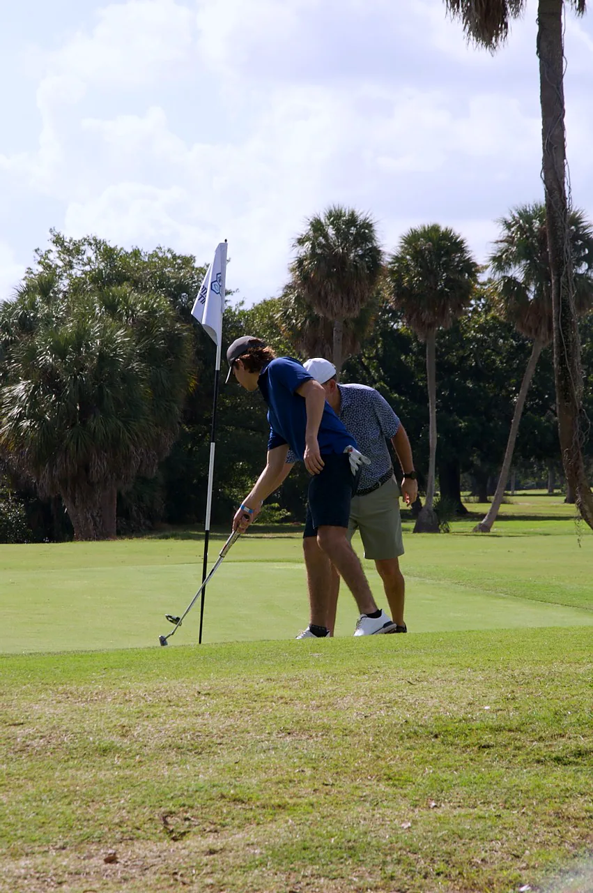 A player lining up a putt at the flag