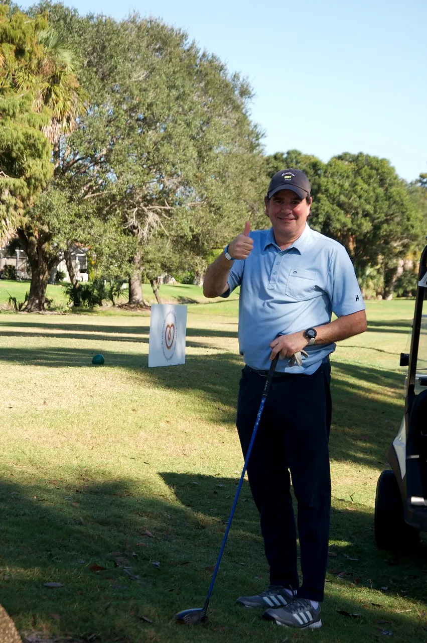A player giving a thumbs up at a sponsored tee sign